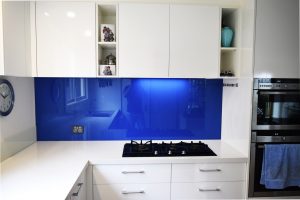 white kitchen with blue coloured glass splashback