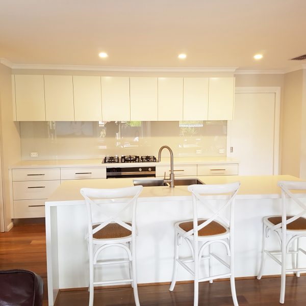 white kitchen with light beige glass splashback